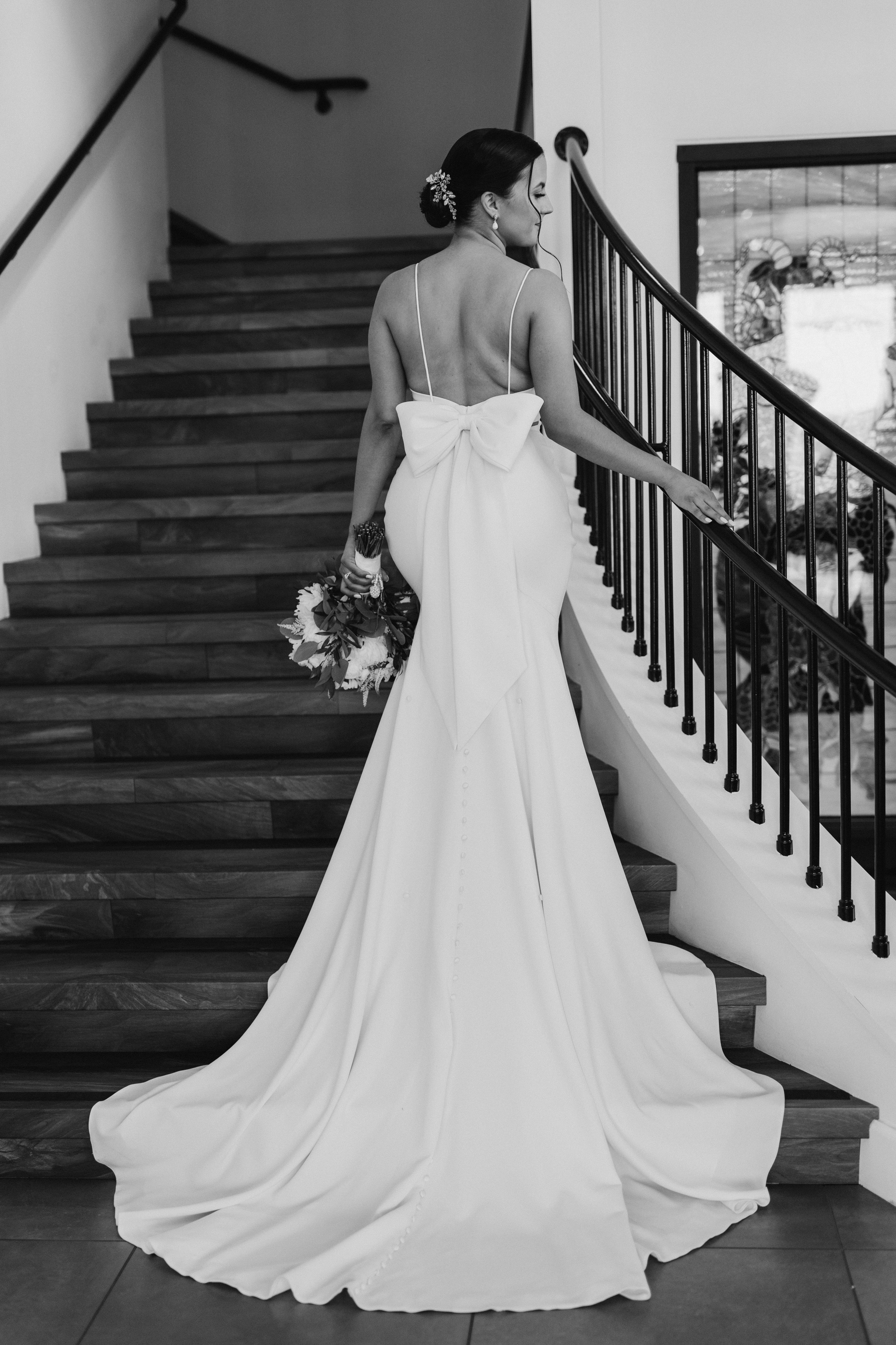 Bride ascending staircase with bow detail