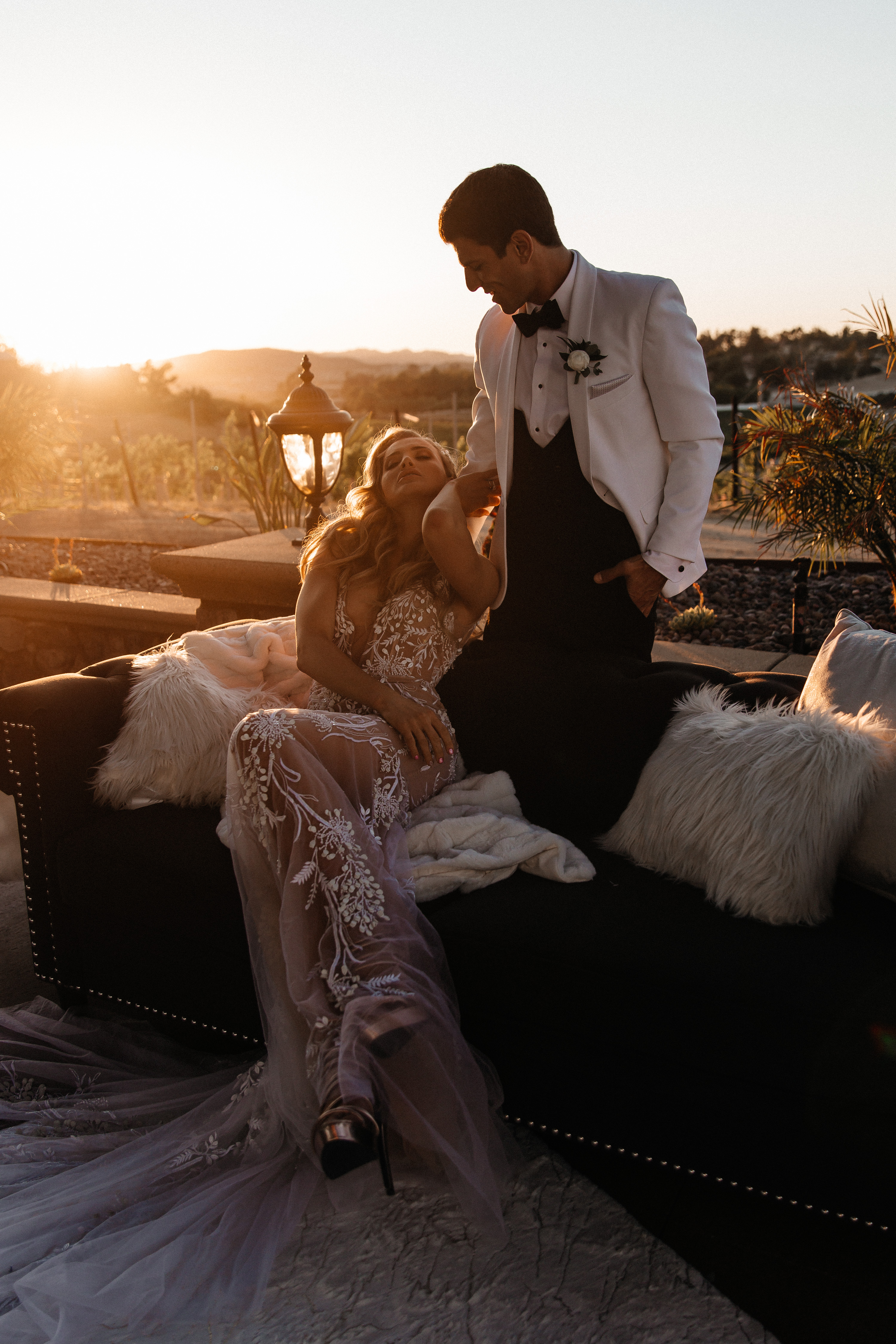Editorial couple on velvet couch at sunset