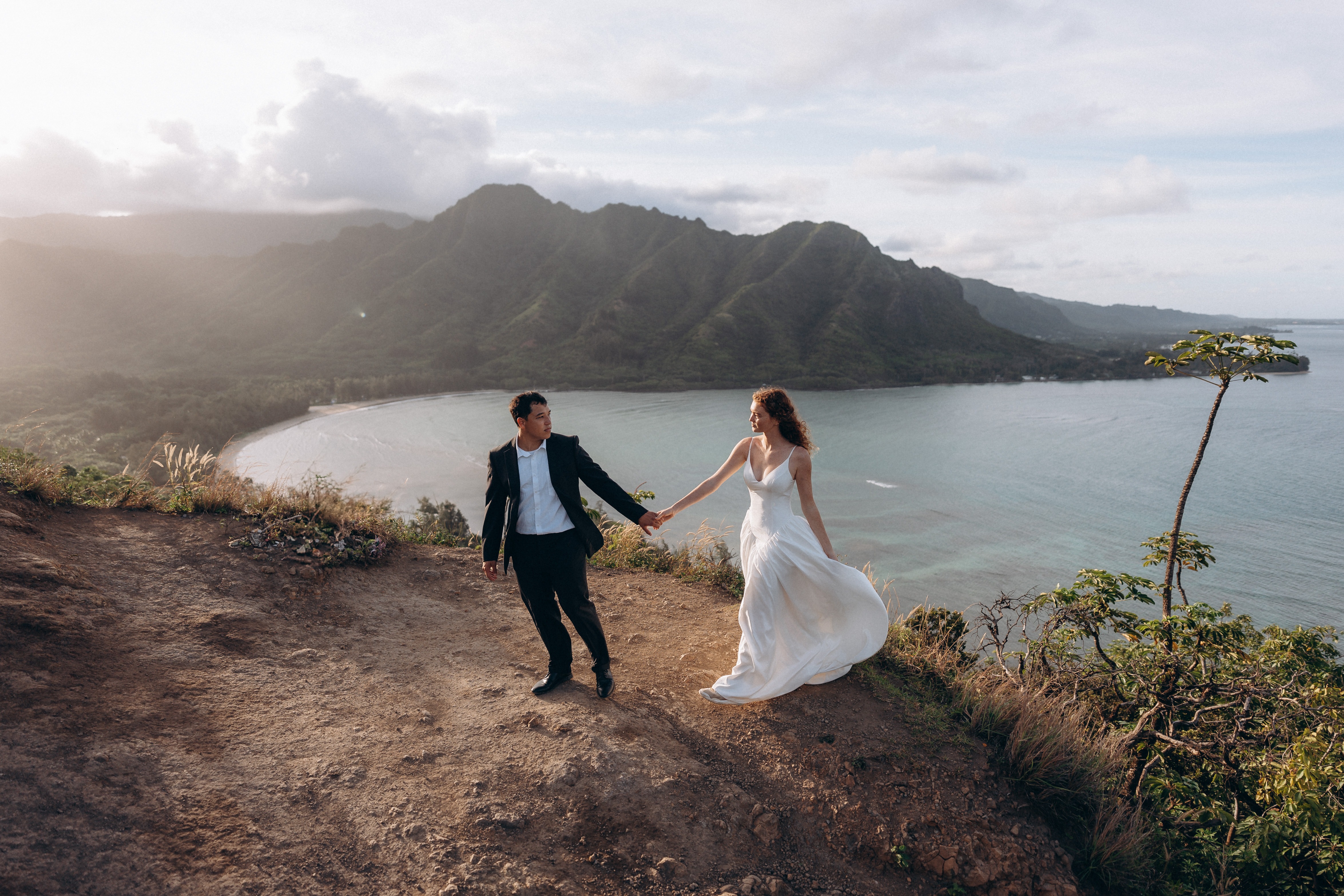 Couple on mountain overlook above tropical bay