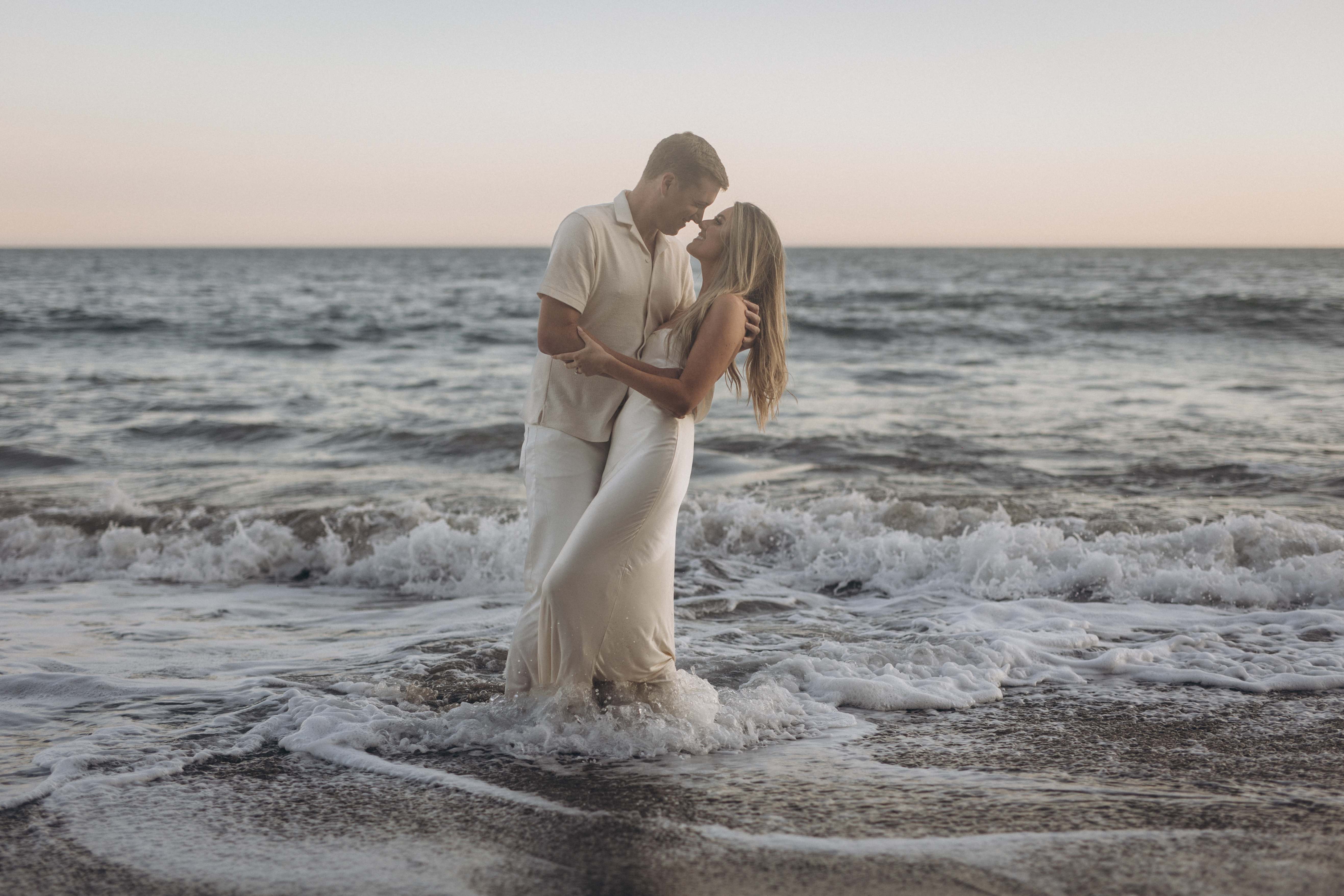 Couple standing in ocean waves