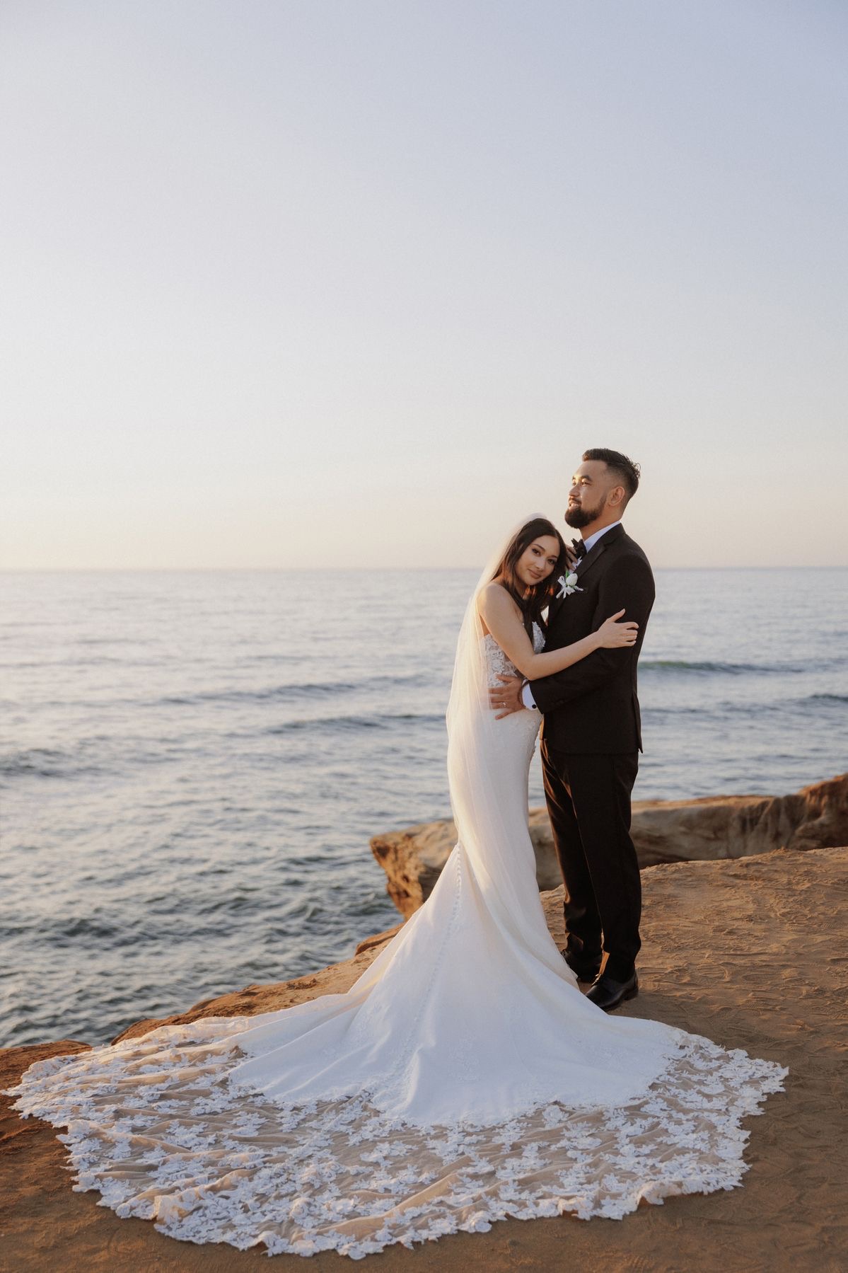Couple on coastal cliff at sunset