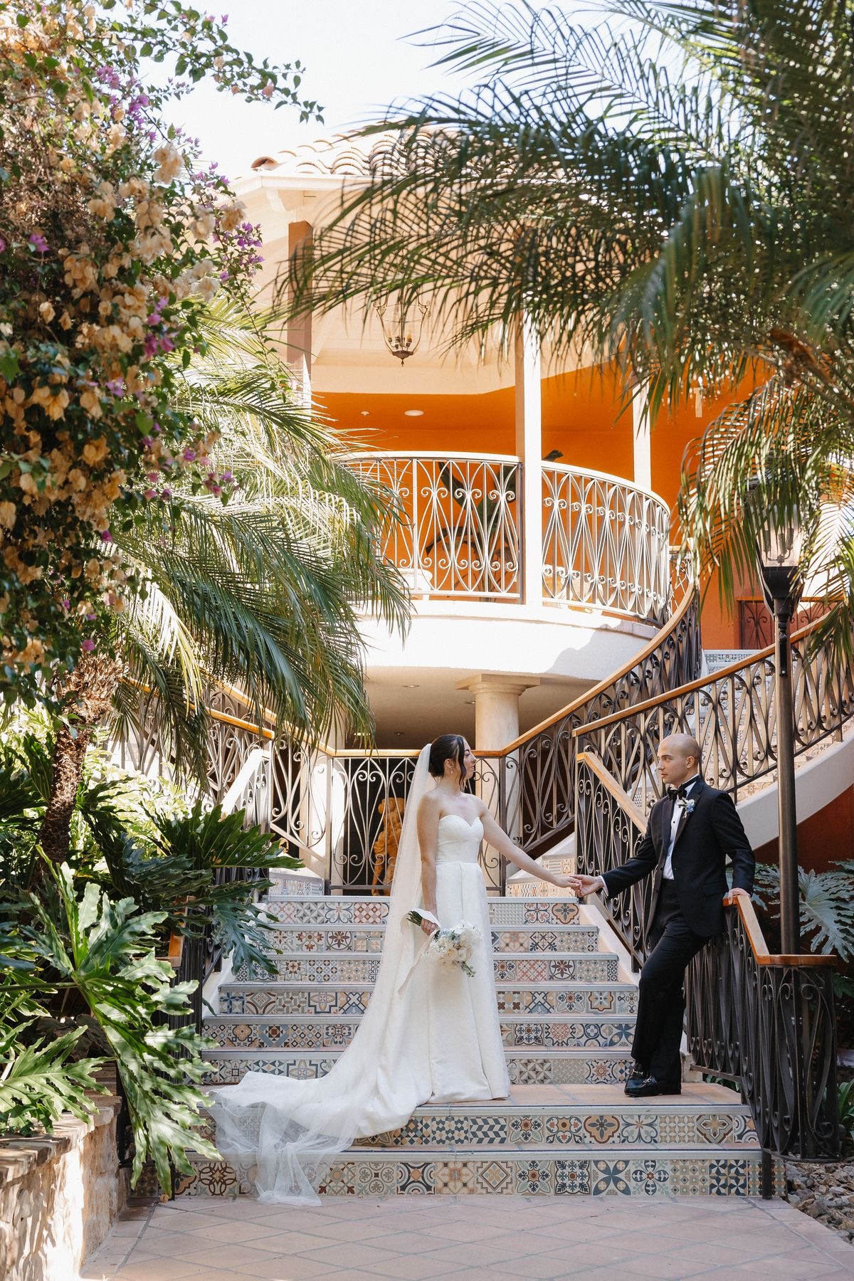 Couple on Spanish-style tiled staircase with tropical plants