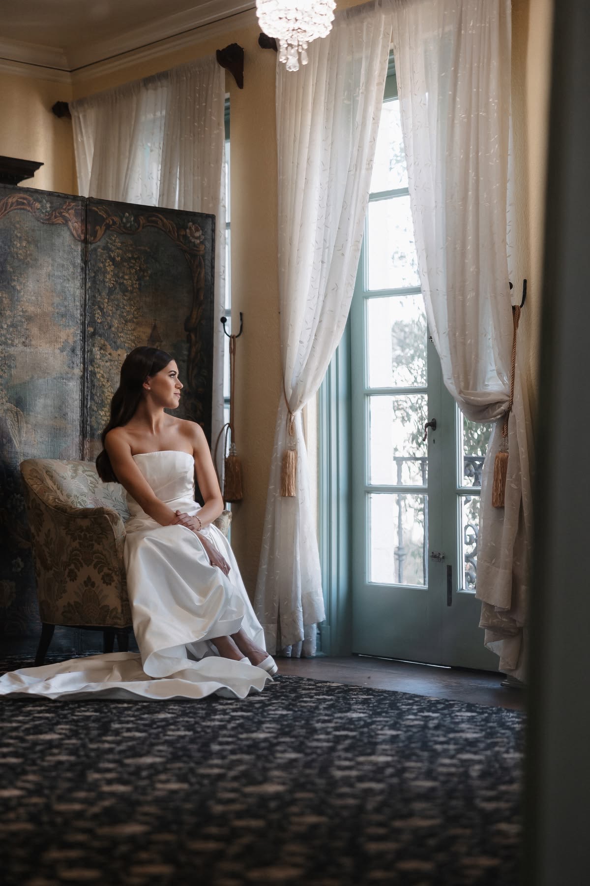 Bride seated by window in vintage room